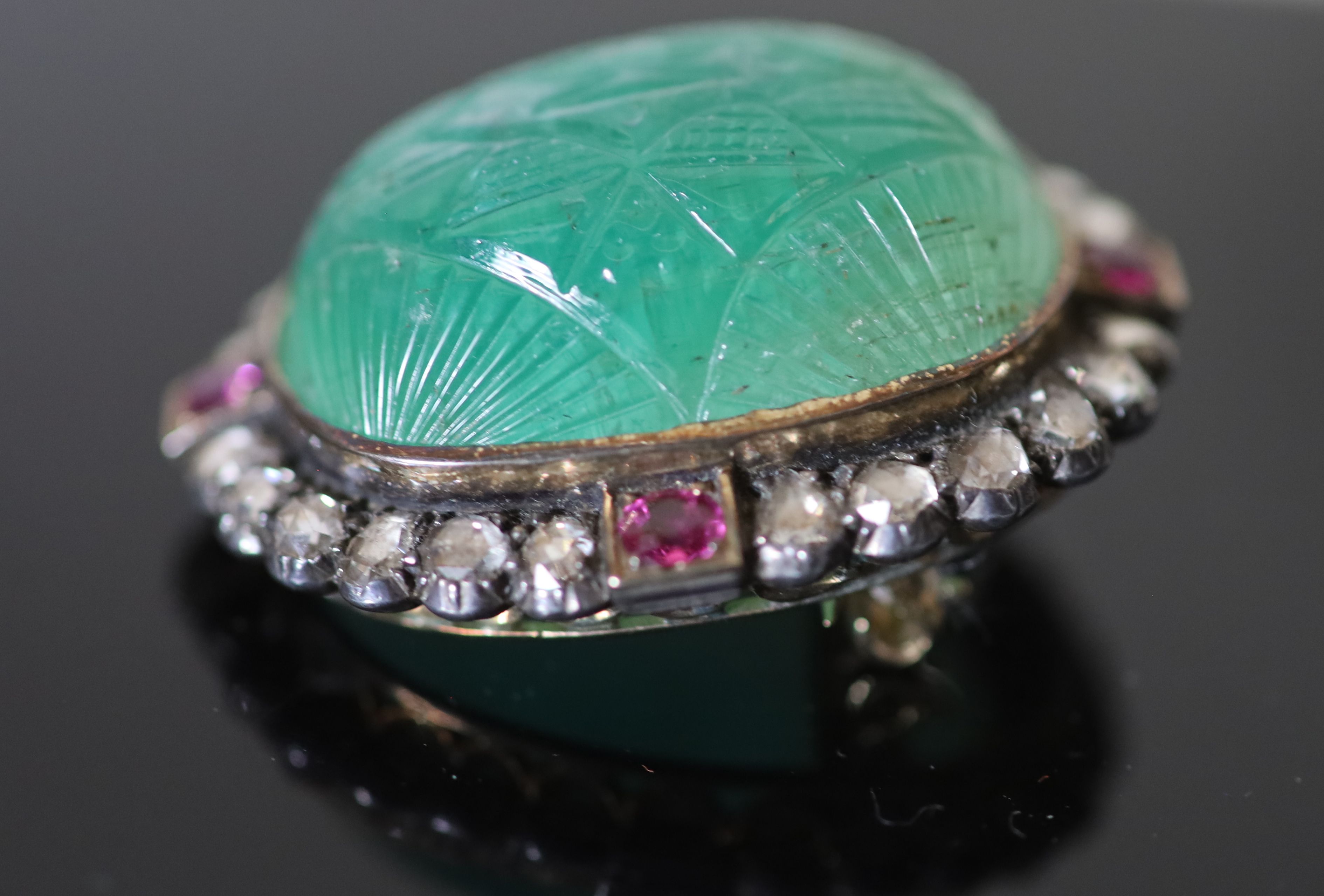 A late 19th century gold and silver, carved emerald, four stone ruby and twenty four rose cut diamond set oval brooch,